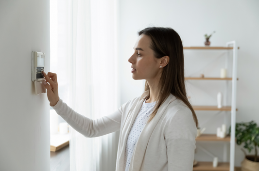 Woman setting her security alarm
